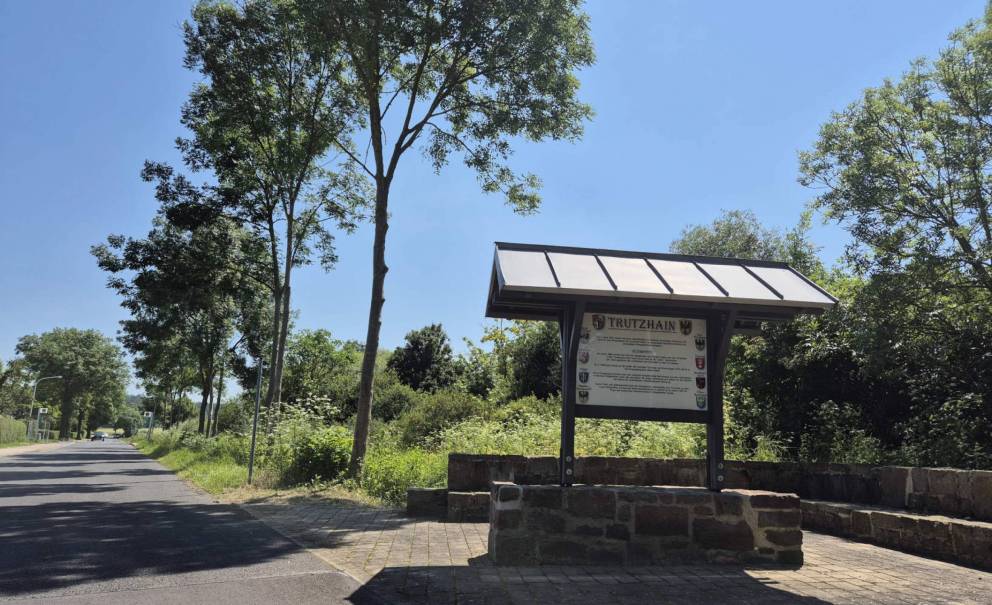 Überdachtes Begrüßungsschild von Trutzhain auf Backstein und Holzrahmen